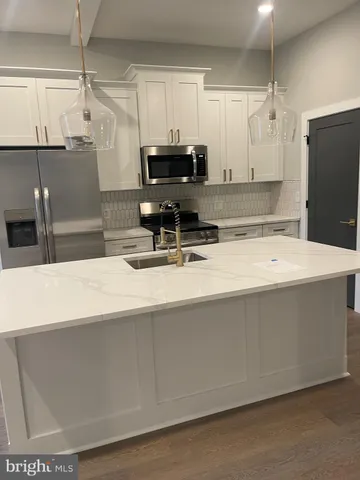 a kitchen with a sink a counter top space cabinets and stainless steel appliances