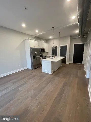 a view of a kitchen with furniture and wooden floor