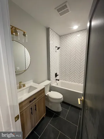 a bathroom with a double vanity sink toilet mirror and bathtub