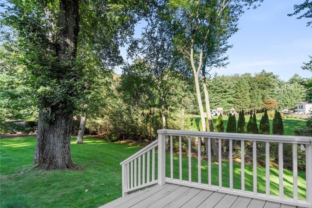 91 Old Colony Road Wellesley, MA 02481 - Photo 32 of 35 a view of a wooden deck next to a yard with large trees