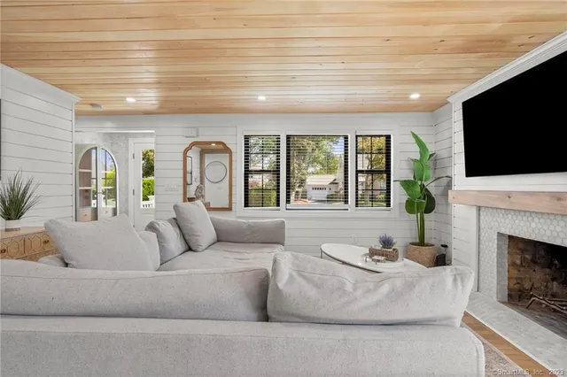 a living room with furniture a fireplace and a flat screen tv