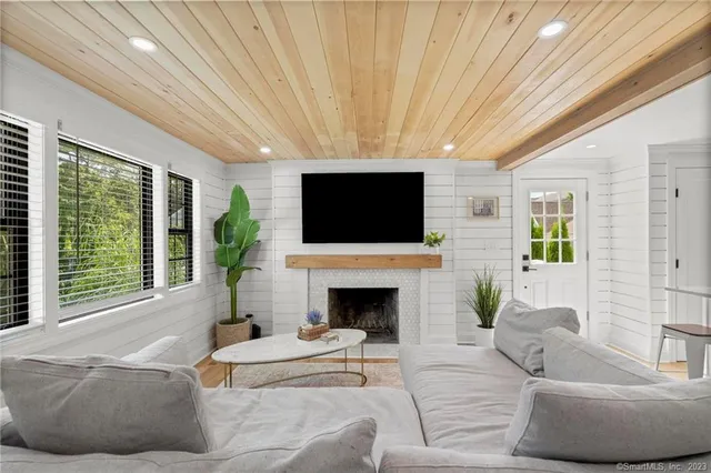 a living room with furniture a flat screen tv and a fireplace
