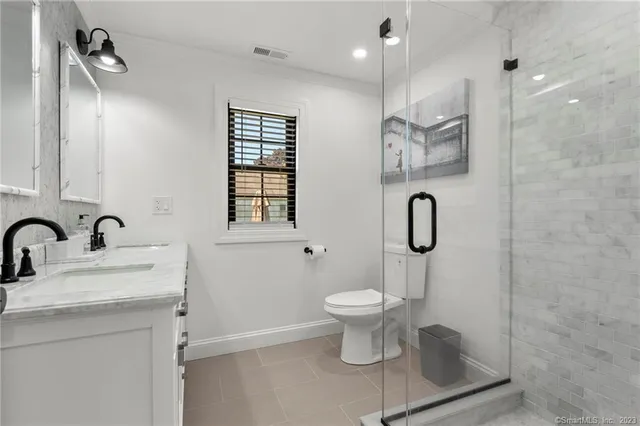 a bathroom with a sink toilet a mirror and shower