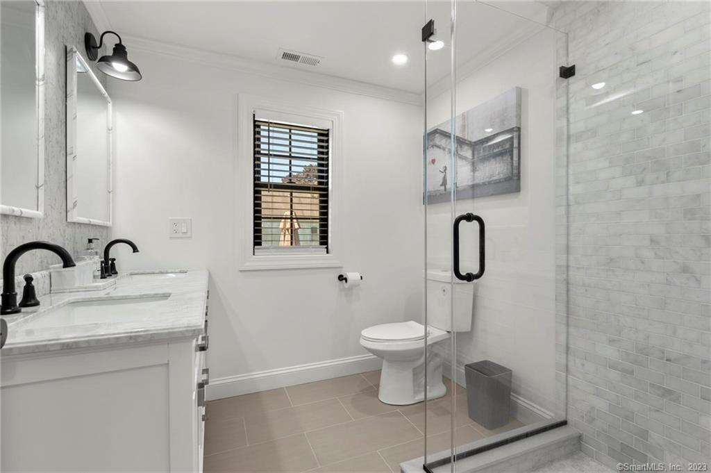 22 Oldfield Drive Fairfield, CT 06824 - Photo 20 of 30 a bathroom with a sink toilet a mirror and shower