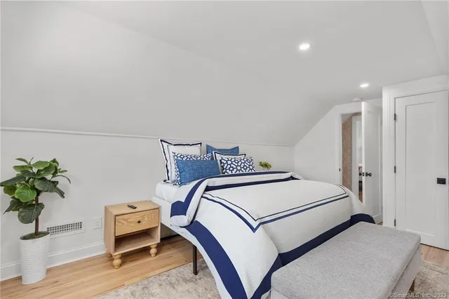 a bedroom with a bed and a potted plant