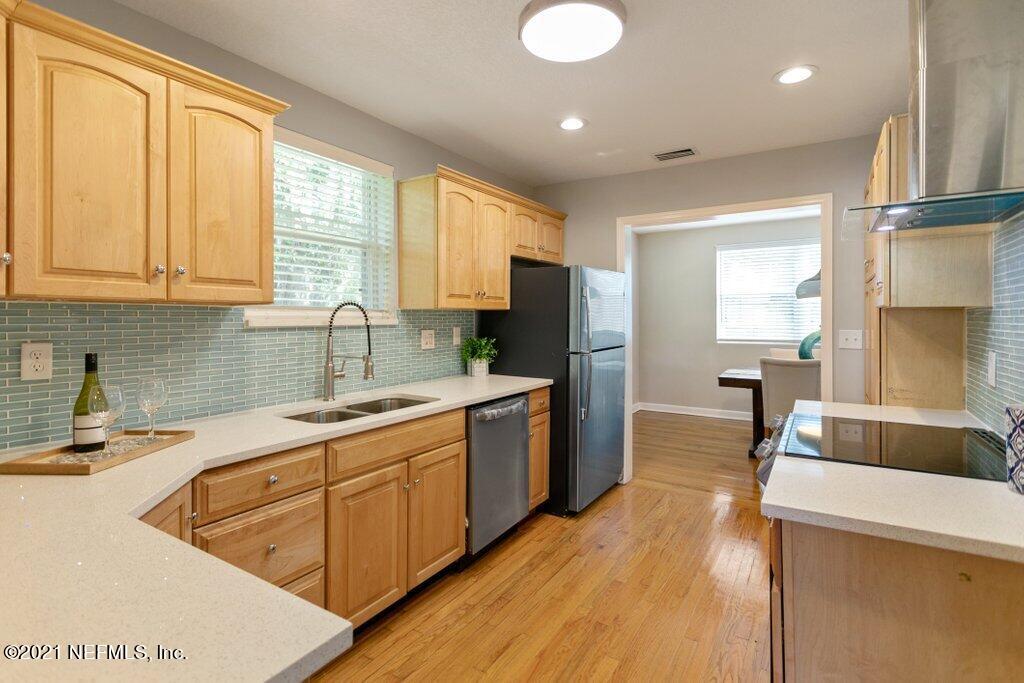 1642 Clemson Road Jacksonville, FL 32217 - Photo 13 of 35 a kitchen with a sink a counter top space a large window and stainless steel appliances