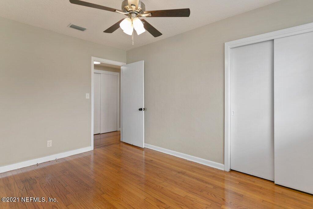 1642 Clemson Road Jacksonville, FL 32217 - Photo 22 of 35 an empty room with wooden floor closet and fan