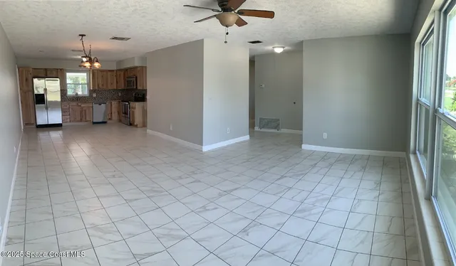 an empty room with chandelier and glass door
