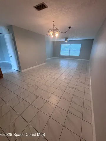a view of a livingroom and a chandelier fan