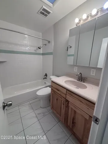 a bathroom with a granite countertop sink a toilet a mirror and shower