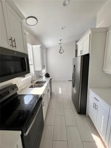 a kitchen with a sink appliances and cabinets