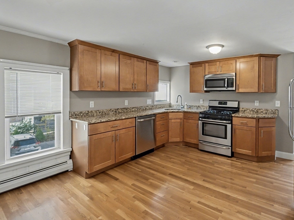 46 Waverly Street, Unit 2 Boston, MA 02135 - Photo 1 of 18 a kitchen with granite countertop a stove top oven sink and cabinets