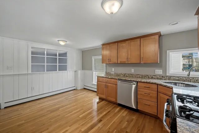 a large kitchen with cabinets wooden floor and a sink