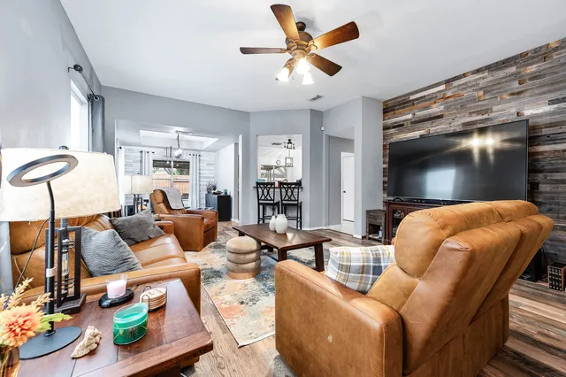 a living room with furniture ceiling fan and a rug