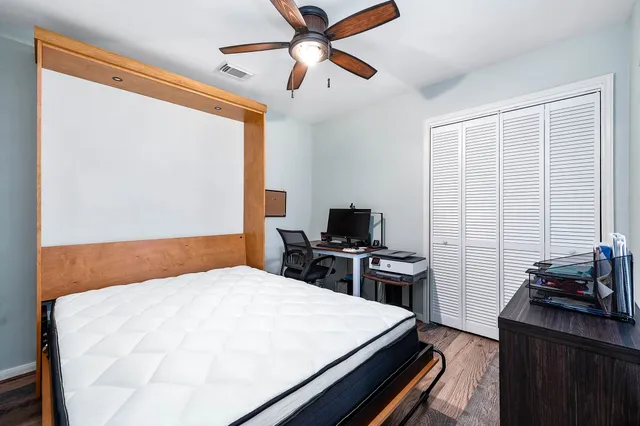 a bedroom with a bed and a computer on a desk