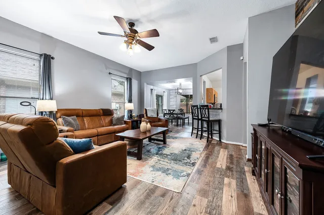 a living room with furniture and a wooden floor