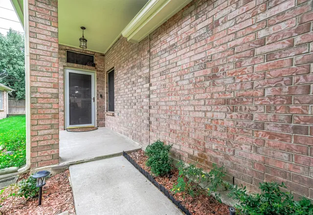 a pathway of a house with potted plants