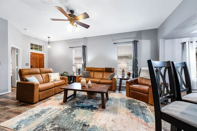 a living room with furniture a ceiling fan and a rug