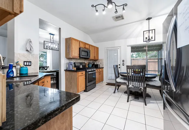 a kitchen with stainless steel appliances granite countertop a sink a stove and a refrigerator