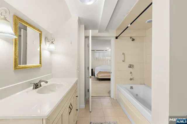 a bathroom with a tub double vanity sink and mirror