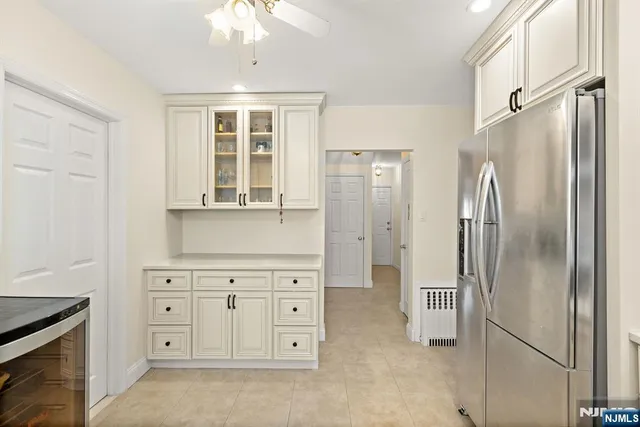 a kitchen with white cabinets and refrigerator