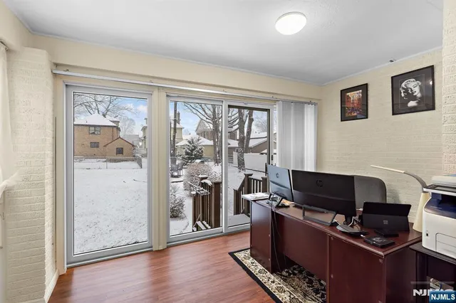 a view of workspace with wooden floor cabinet and windows