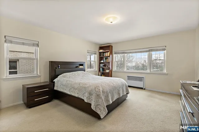 a bed sitting in a spacious bedroom next to a window