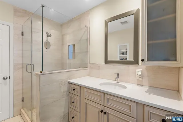 a bathroom with a shower sink and mirror