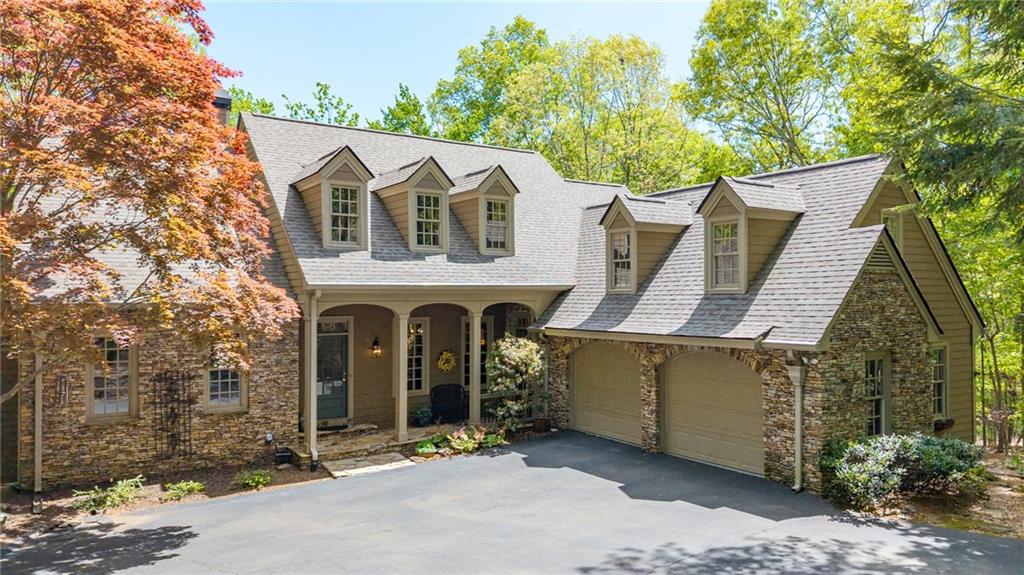 a view of a house with brick wall and a large tree
