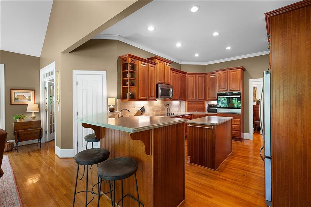 208 Muirfield Way Jasper, GA 30143 - Photo 13 of 59 a kitchen with stainless steel appliances granite countertop a refrigerator a sink dishwasher a stove and a dining table with wooden floor