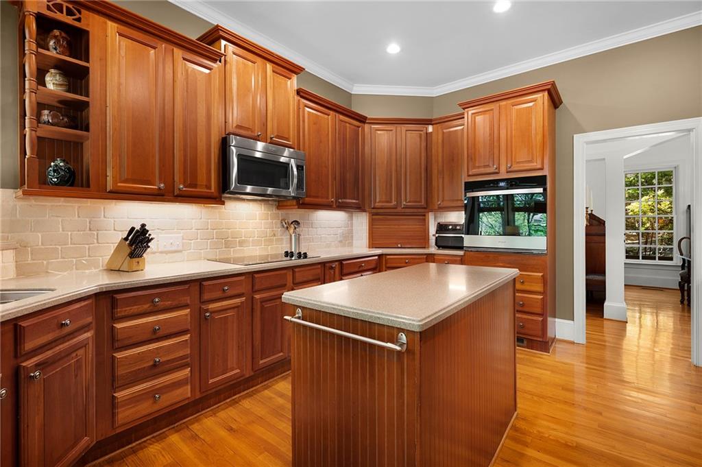 208 Muirfield Way Jasper, GA 30143 - Photo 15 of 59 a kitchen with stainless steel appliances granite countertop wooden cabinets a sink a stove a dining table and chairs