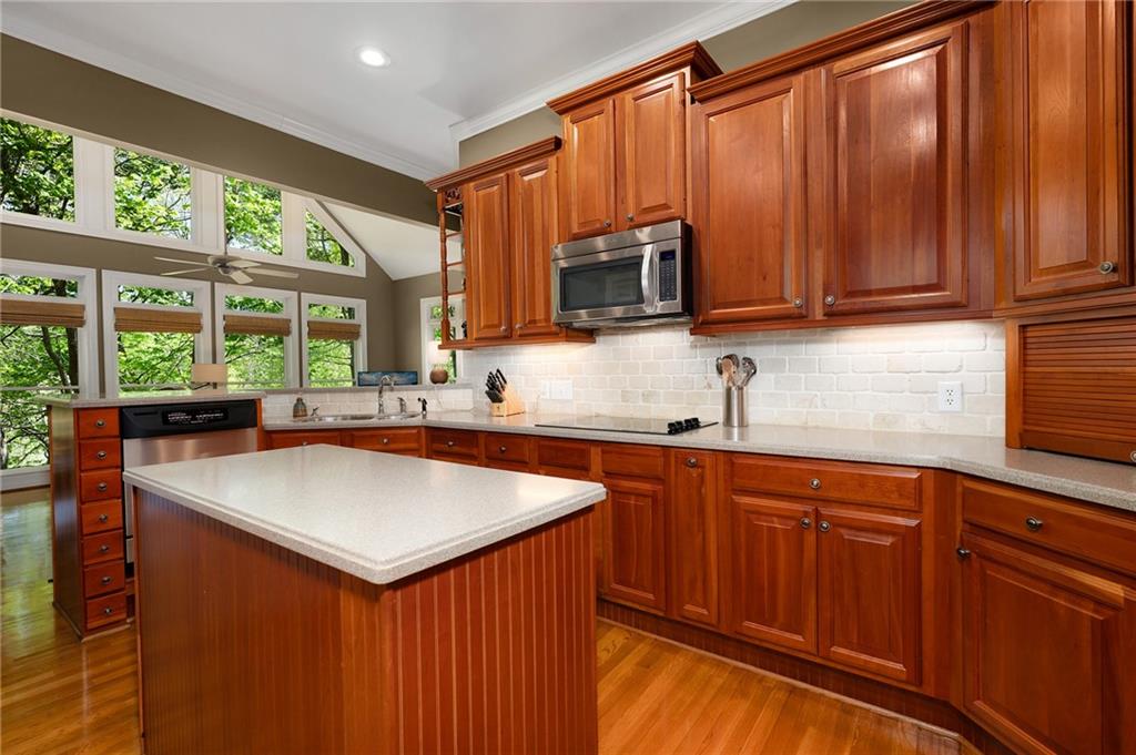 208 Muirfield Way Jasper, GA 30143 - Photo 16 of 59 a kitchen with stainless steel appliances wooden cabinets a sink and a microwave