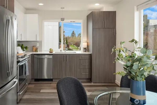 a kitchen with stainless steel appliances granite countertop a refrigerator a stove top oven a sink and dishwasher