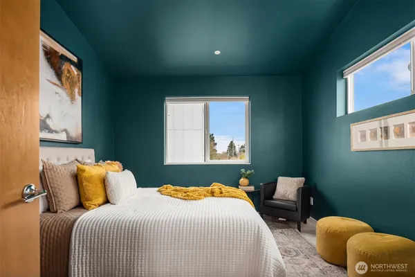 a bedroom with bed and a painting on the wall