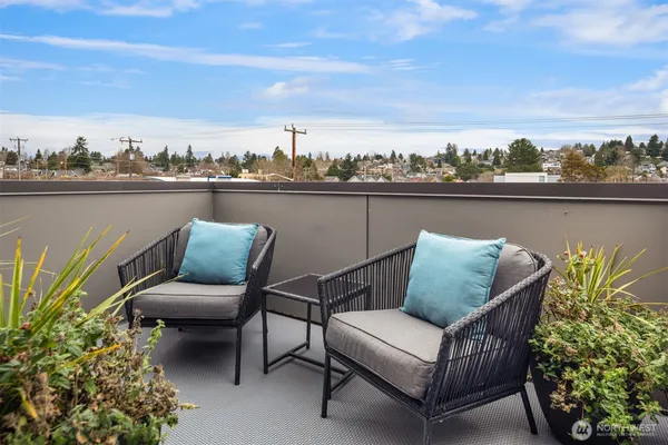 a couple of chairs sitting in a roof deck with a lake view