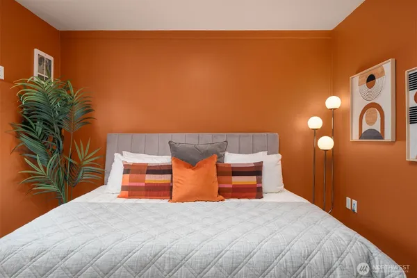 a bedroom with bed and a painting on the wall