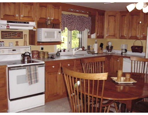 10 Wedgewood Road Sturbridge, MA 01566 - Photo 7 of 14 a kitchen with stainless steel appliances granite countertop a stove a sink dishwasher and cabinets with wooden floor