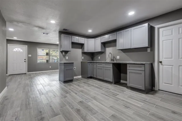 a kitchen with stainless steel appliances granite countertop a sink refrigerator and cabinets