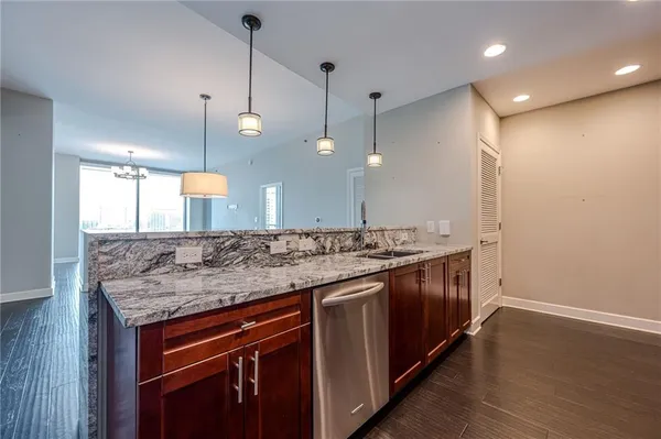 a kitchen with granite countertop wooden cabinets and stainless steel appliances