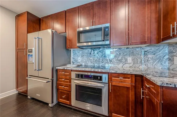 a metallic refrigerator freezer sitting inside of a kitchen