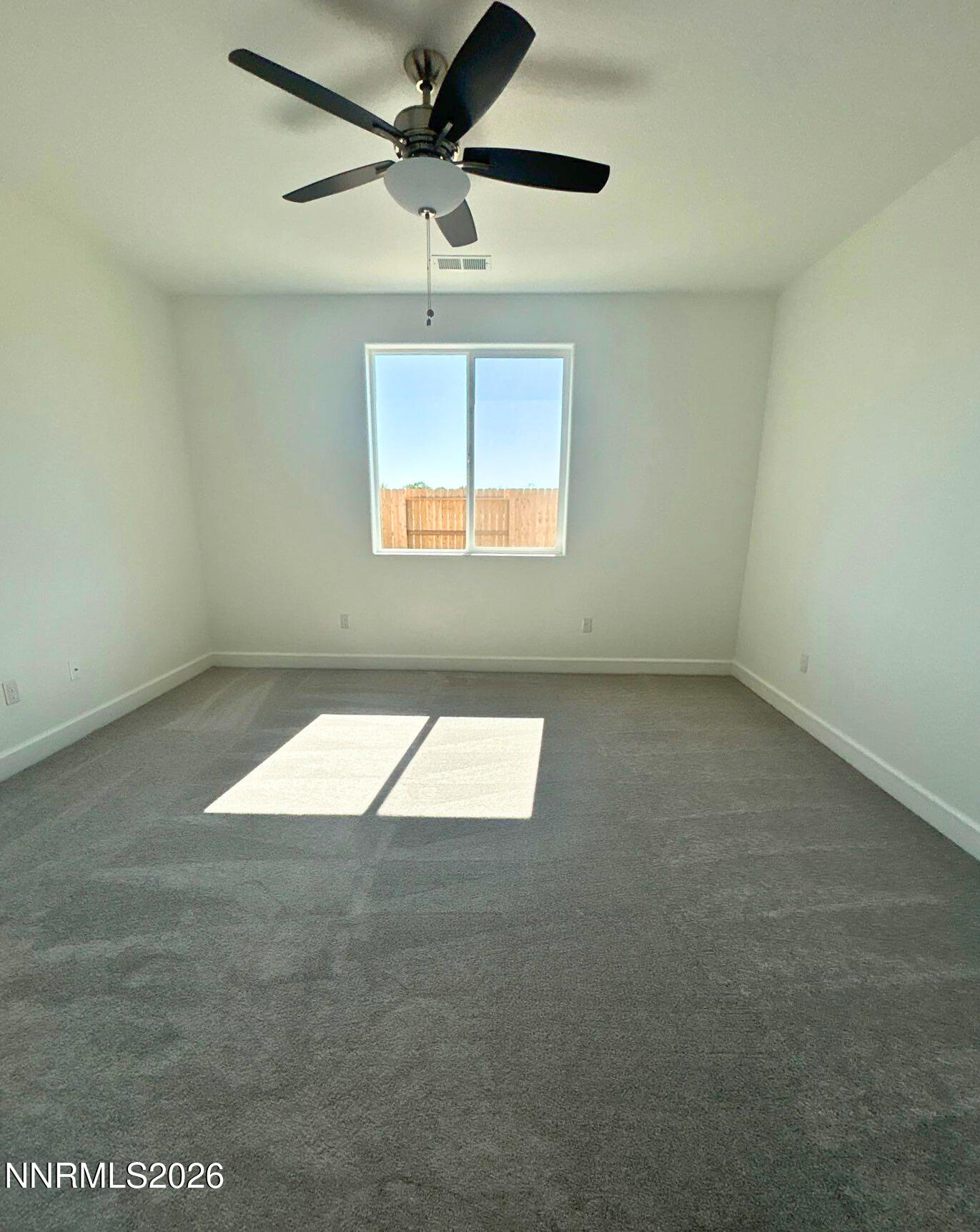 3453 Payton Way Fernley, NV 89408 - Photo 8 of 15 an empty room with a window and a ceiling fan