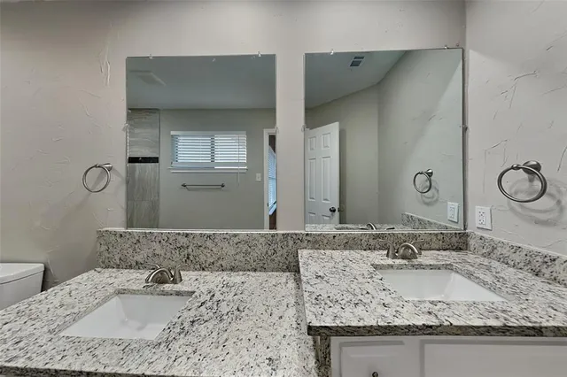 a bathroom with a granite countertop sink and a mirror