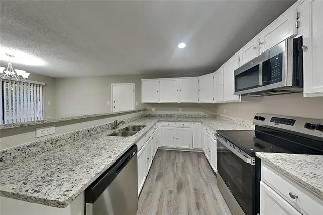 a kitchen with stainless steel appliances granite countertop a stove a sink and a microwave