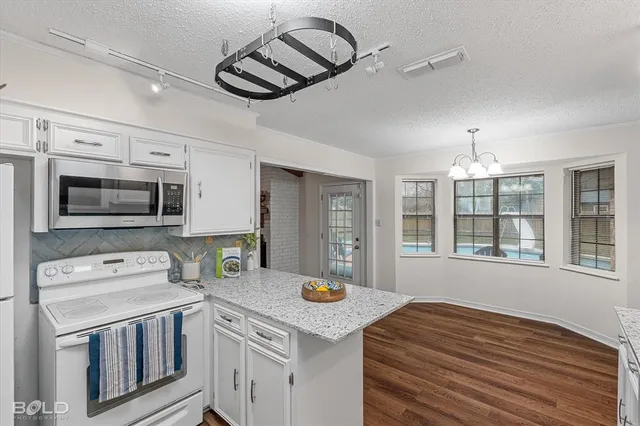 a kitchen with stainless steel appliances granite countertop a refrigerator a stove and a sink