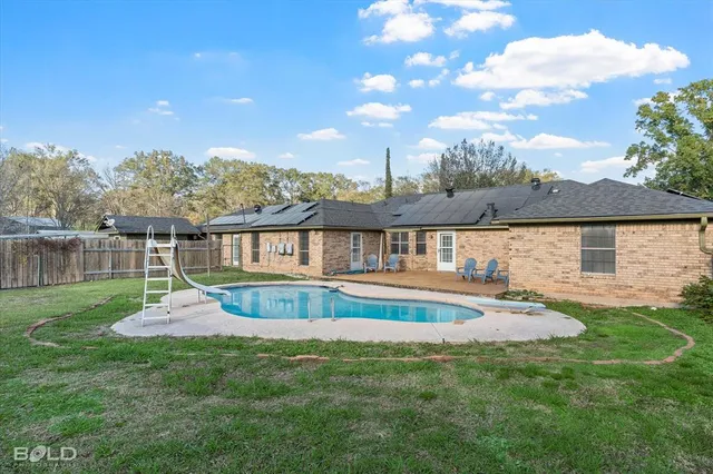 a view of a house with backyard and garden