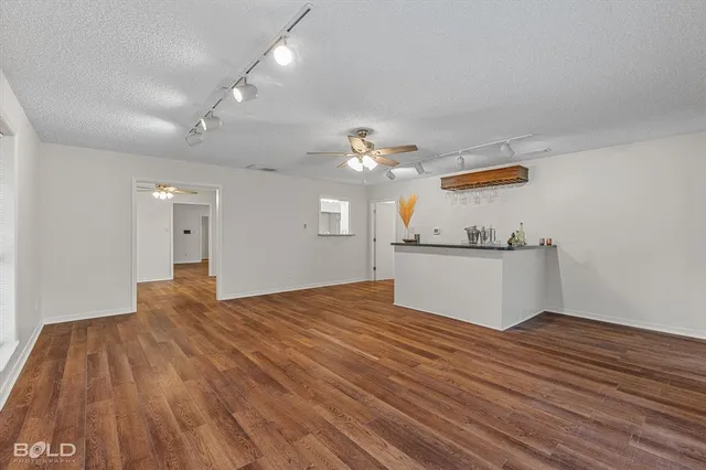 a view of a kitchen with cabinets and wooden floor