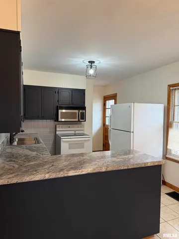 a kitchen with granite countertop a sink and a stove top oven