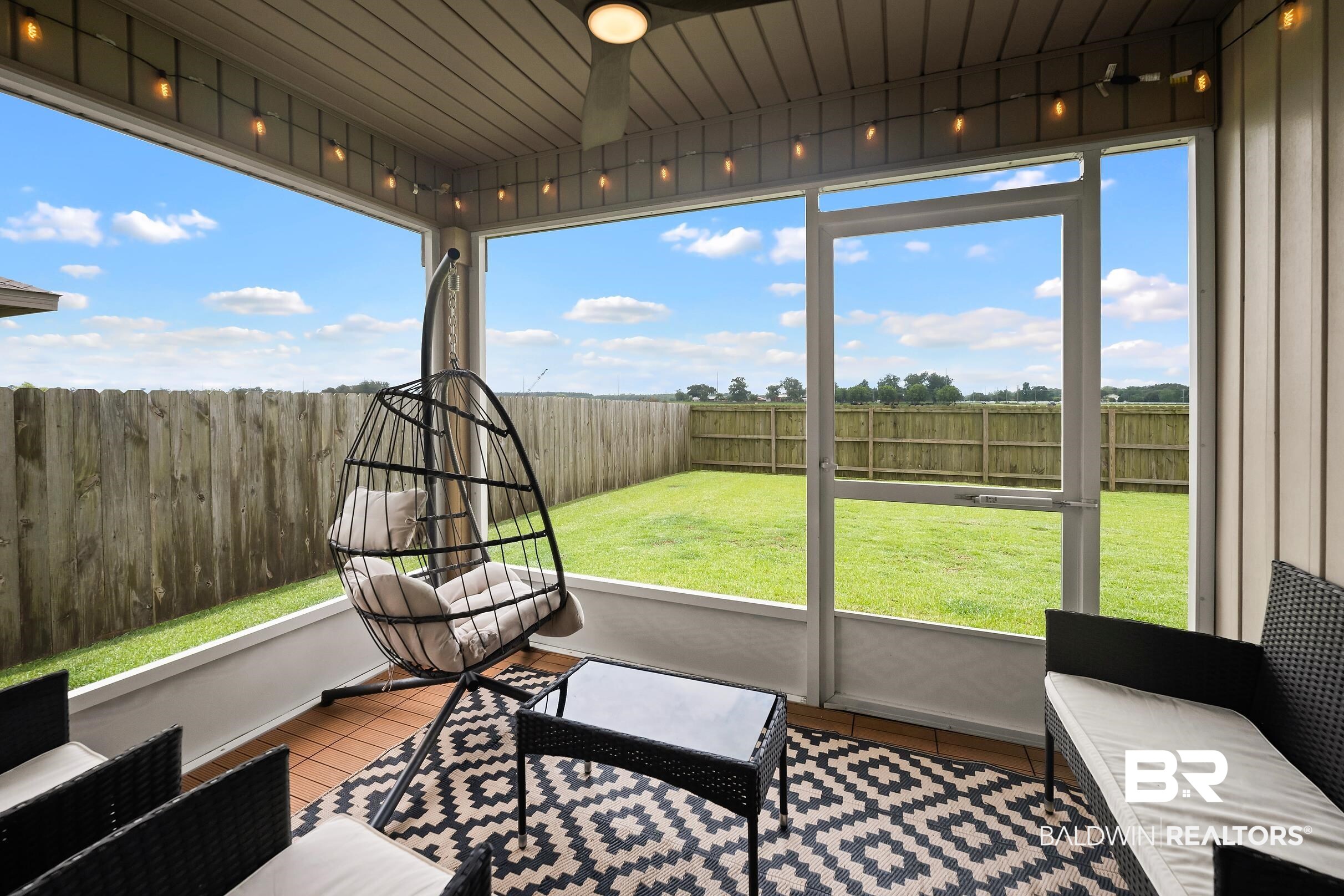 32030 Terranova Loop Lillian, AL 36549 - Photo 21 of 30 Screened porch featuring a ceiling fan, string lighting, and wood-finish flooring