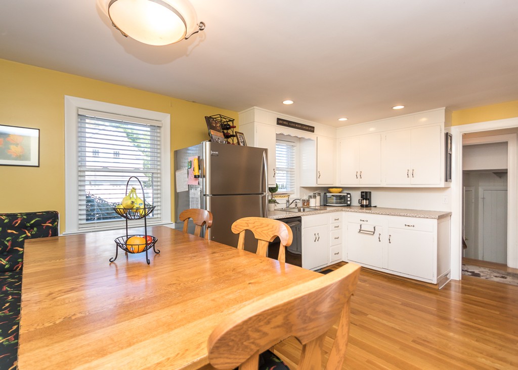 87 Evelyn Road Needham, MA 02494 - Photo 5 of 14 a kitchen with a sink dishwasher stove and refrigerator with wooden floor