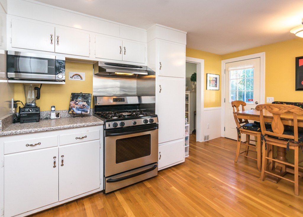 87 Evelyn Road Needham, MA 02494 - Photo 6 of 14 a kitchen with stainless steel appliances a stove a sink dishwasher and a refrigerator with wooden floor
